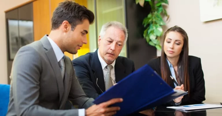 Two men and a woman looking at information for respondents