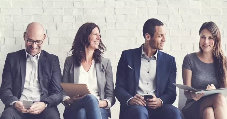 Two men and two women sitting at a table smiling, discussing their careers at Investigative Services Group